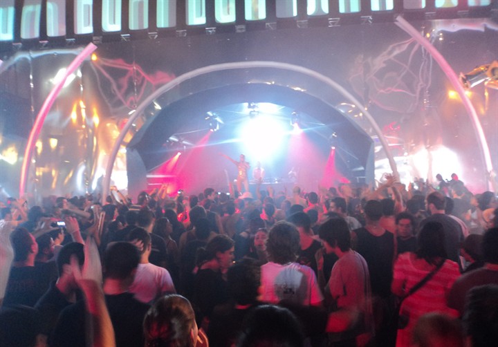 Público em show com iluminação cenográfica
