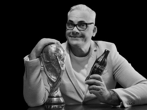 Executivo com troféu e garrafa Coca-Cola