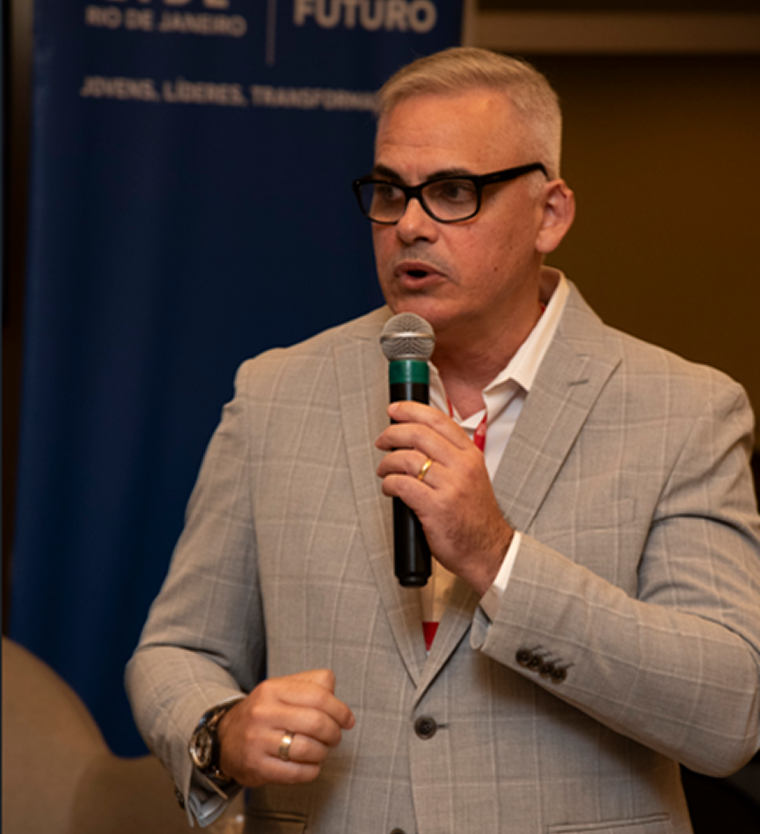 Hélio falando ao microfone em evento